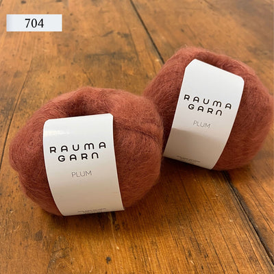 Two balls of Rauma Plum, a laceweight mohair blend yarn, in color 704, muted rosy orange.