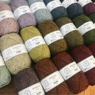 An array of balls of Rauma Finullgarn, a fingering/sport weight yarn, in a range of heathered colors