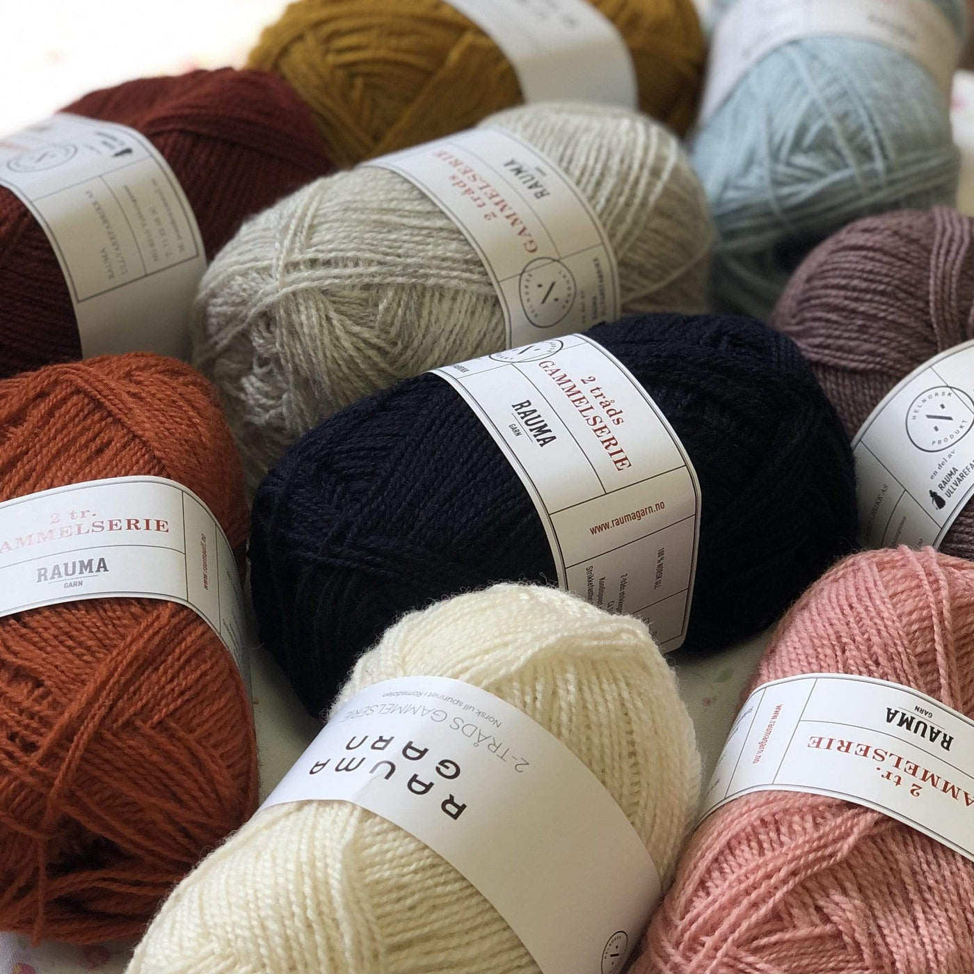 An assortment of skeins of Rauma Gammelserie on a table