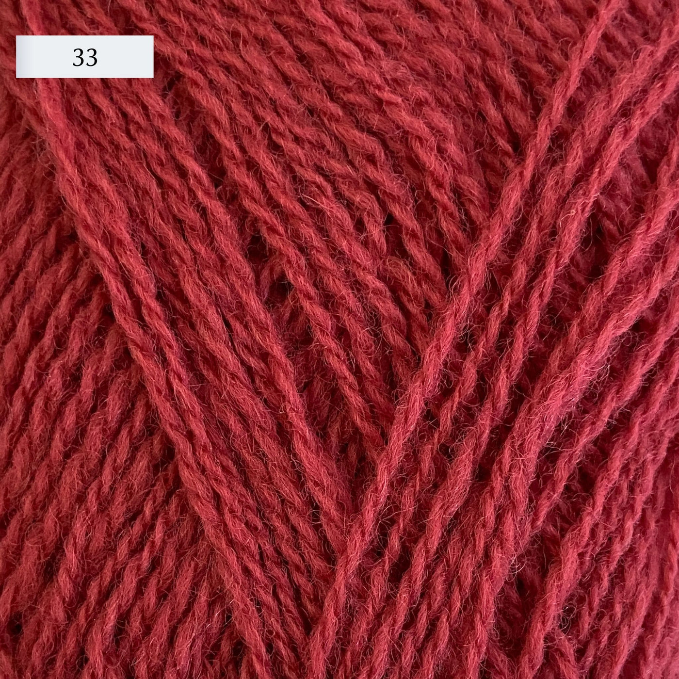 Rauma Lamullgarn, a fingering weight yarn, in color 33, a saturated red-coral