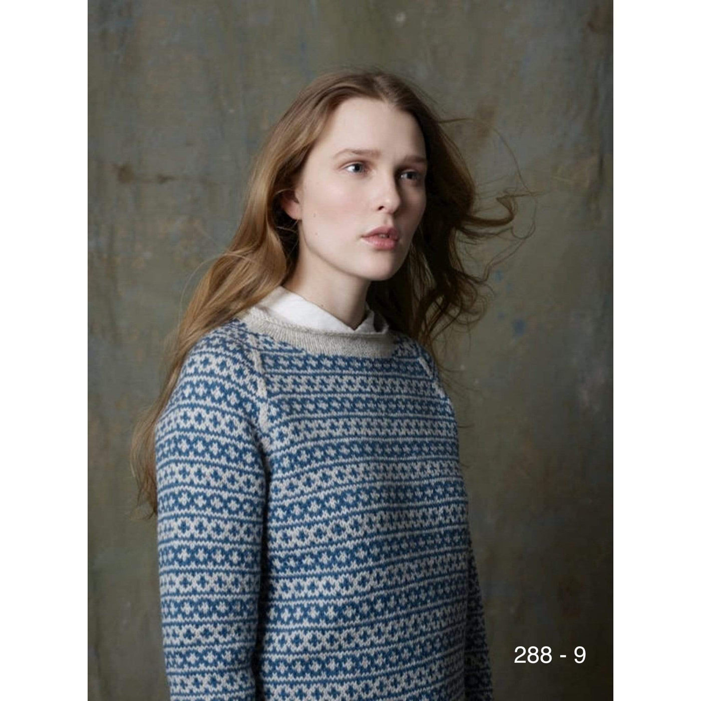 A woman in an overall colorwork pullover knit in Rauma Strikkegarn using pattern 288-9.