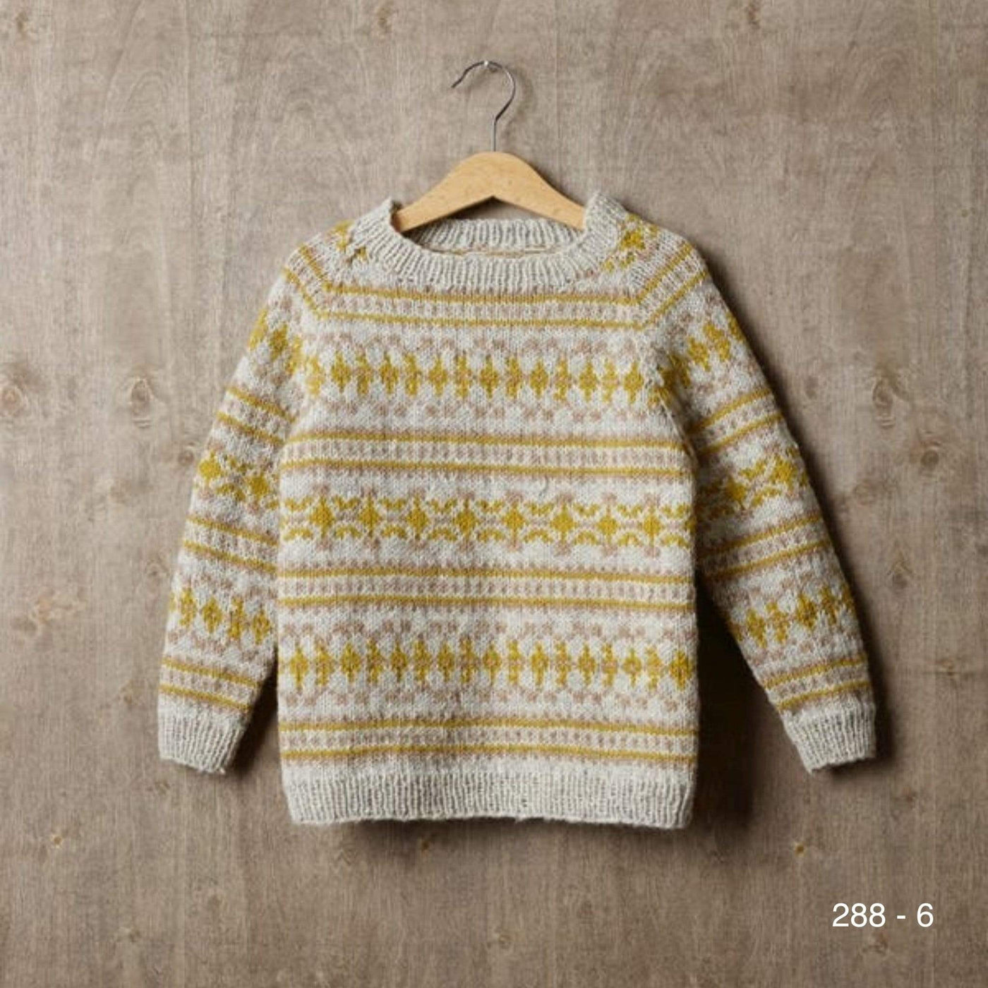 A child's overall colorwork pullover pattern 288-6 knit in Rauma Strikkegarn.
