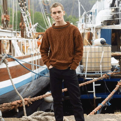 Man wearing knitted brown sweater from Rauma Finullgarn pattern book from the Woolly Thistle