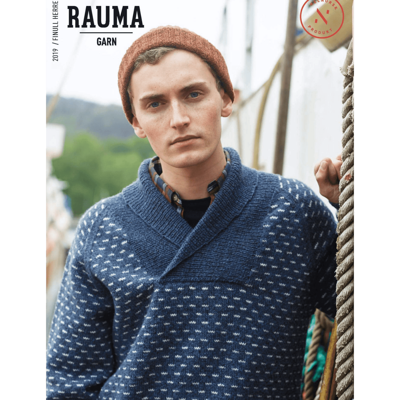 Man wearing knitted blue and cream patterned sweater and burnt orange hat from Rauma Finullgarn Herre pattern book from the Woolly Thistle