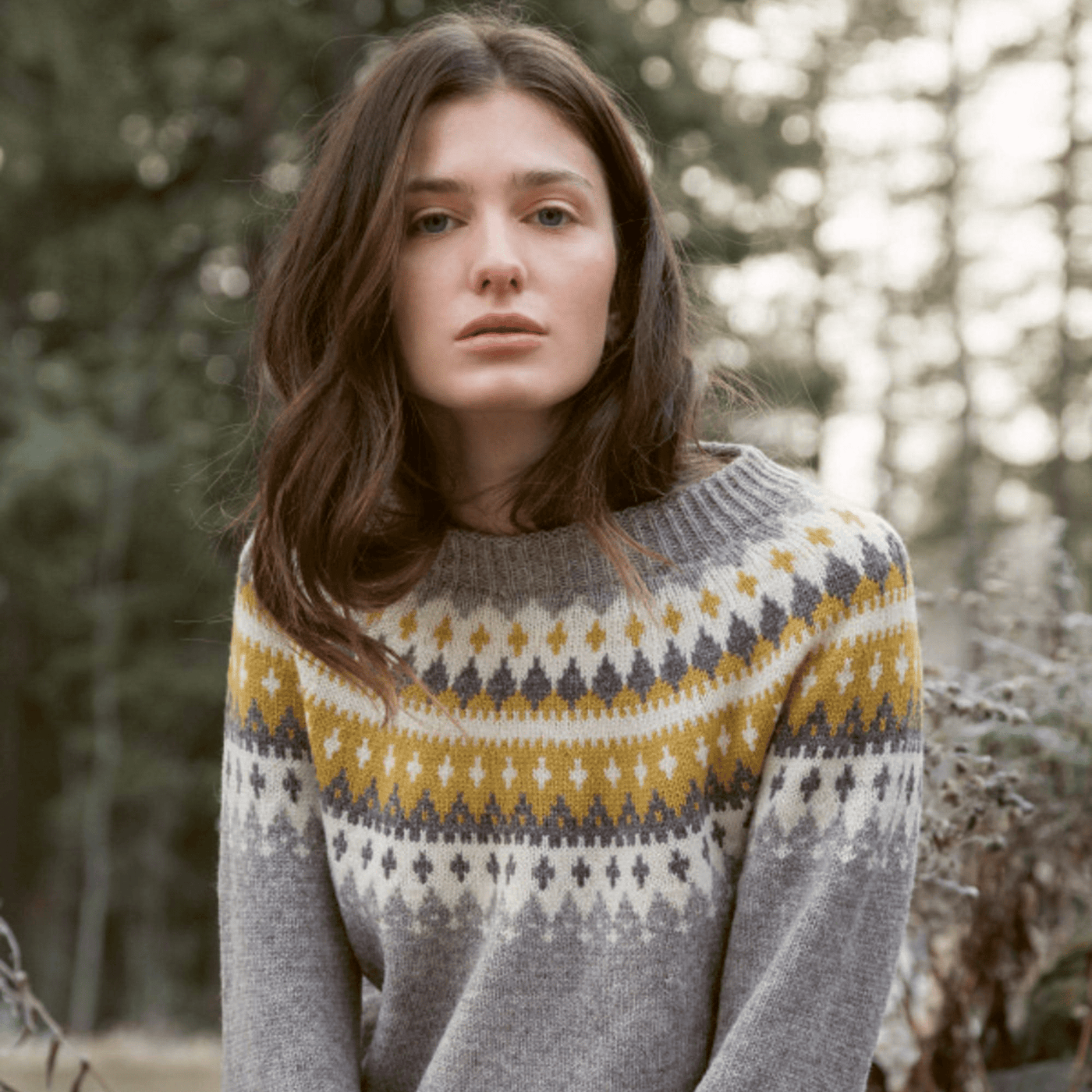 Woman wearing knitted tan, yellow, and grey patterned sweater from Rauma Finullgarn Varde pattern book from the Woolly Thistle.