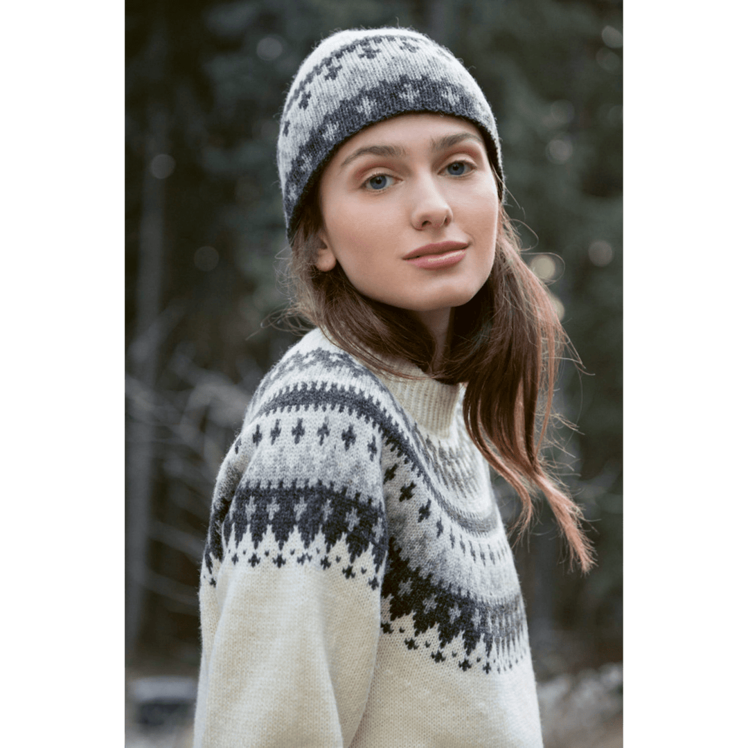 Woman wearing knitted cream and grey patterned sweater and hat from Rauma Finullgarn Varde pattern book from the Woolly Thistle.