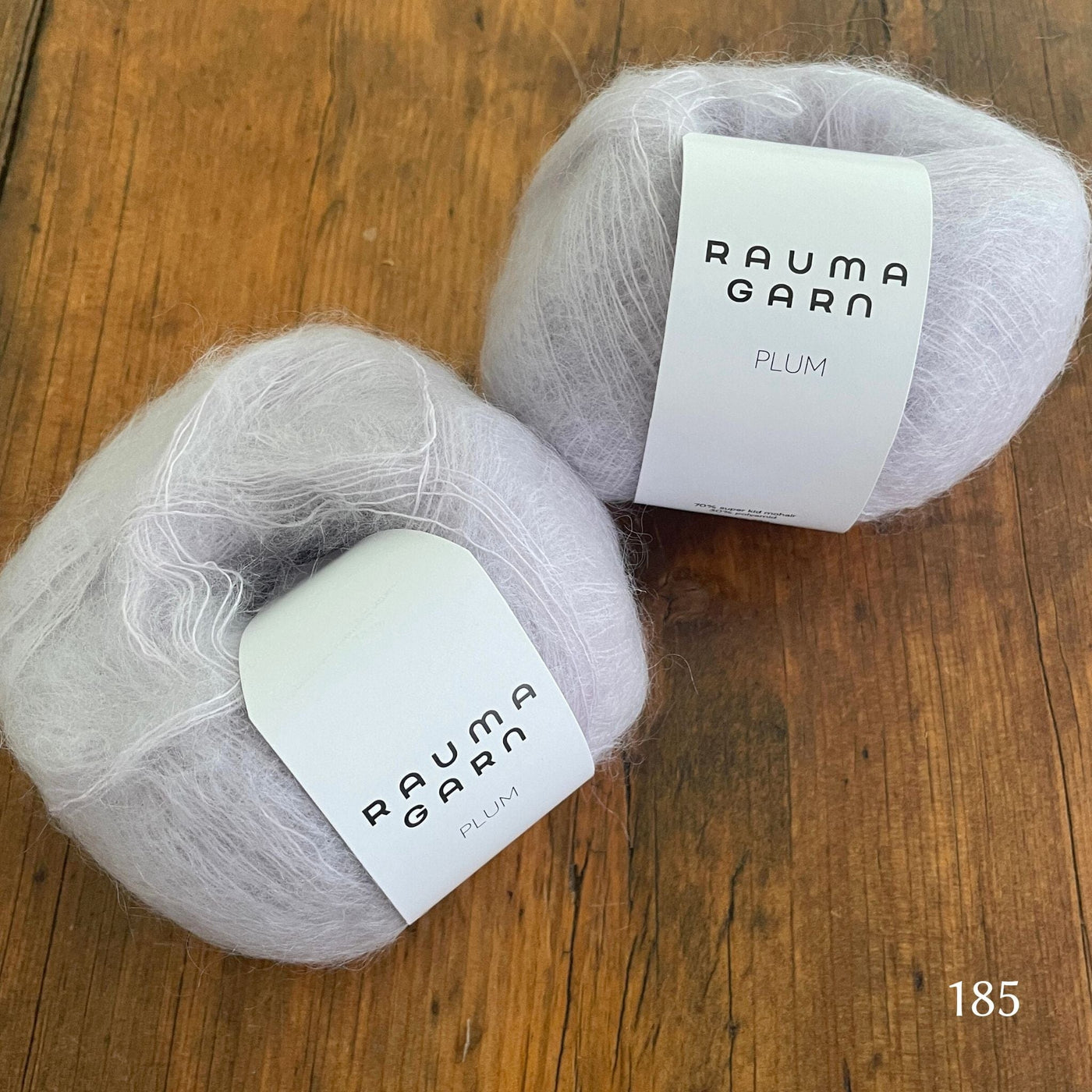 Two balls of Rauma Plum, a laceweight mohair blend yarn, in color 185, an ice grey
