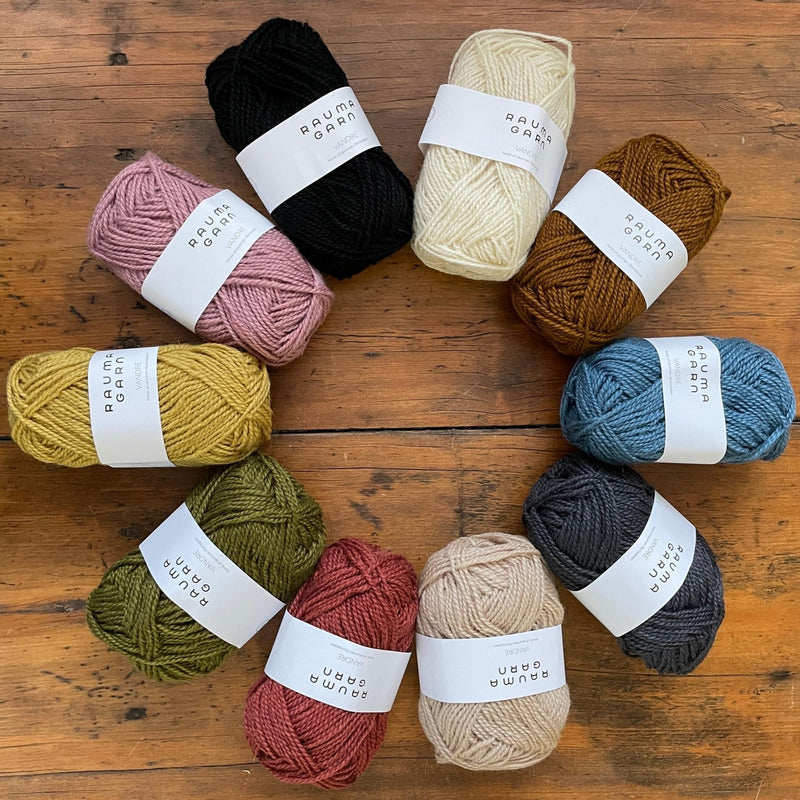 10 balls of Rauma Vandre yarn in different colors, arranged in a ring.  