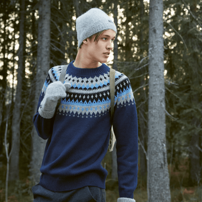 The Woolly Thistle Varde Yoke Sweater 275R in Rauma Finullgarn- blue patterned sweater, grey beanie, and grey mittens.