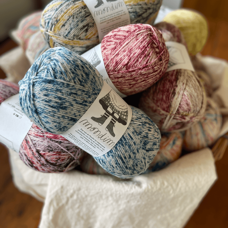 The Woolly Thistle Retrosaria Mondim Fingering Weight Yarn in multi-colors like blue/cream, pink/cream, yellow/cream, and more