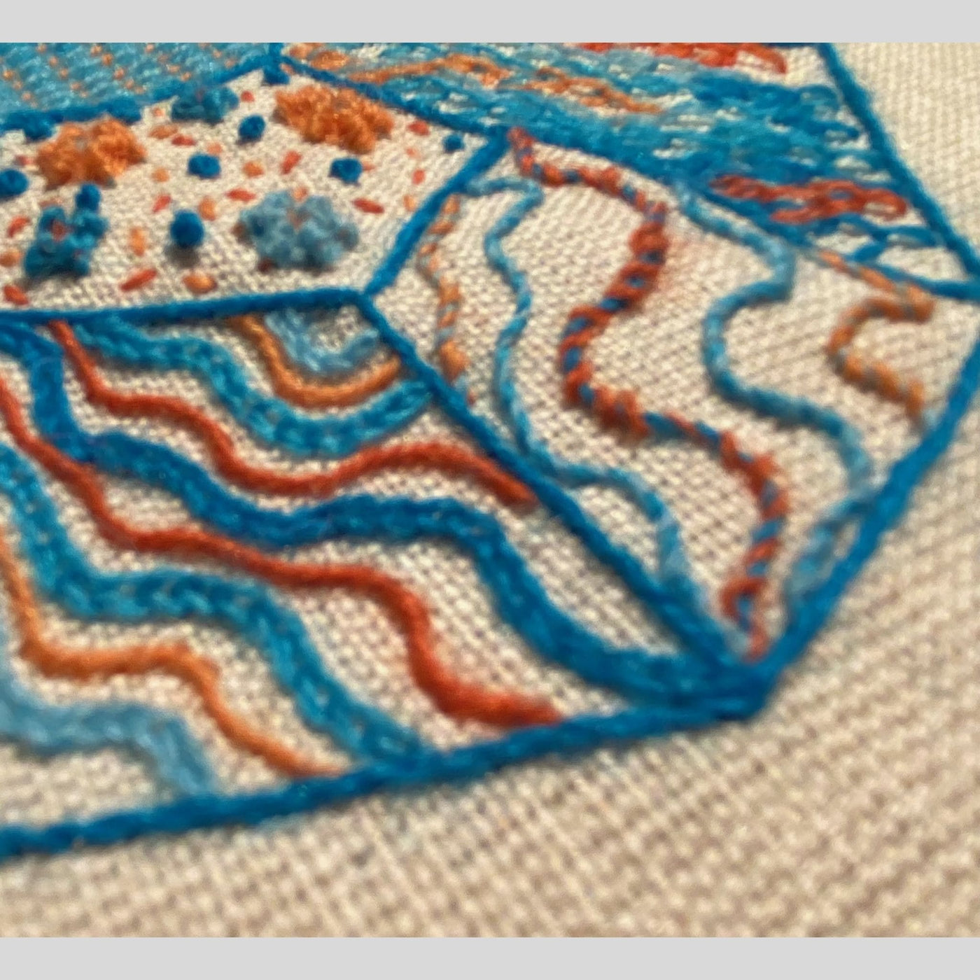 Page from Yarn-The Journal of Scottish Yarns publication. Blue and orange stitches on neutral background.