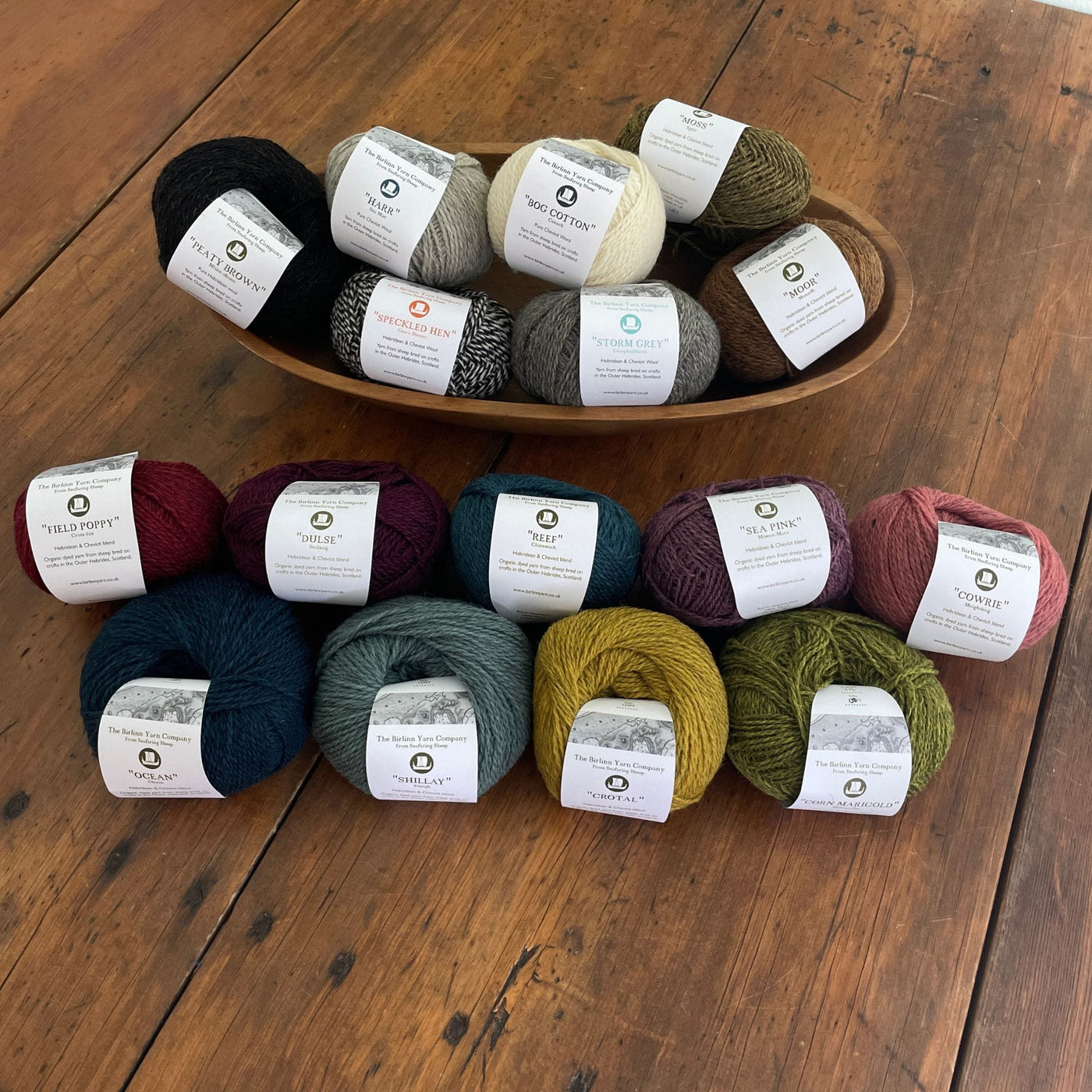 Birlinn Yarn Company Hebridean 4ply yarns shown in various colors on wooden table.