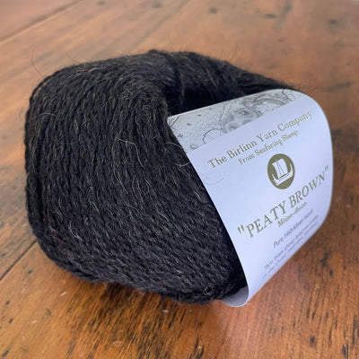 Birlinn Yarn Company Hebridean 4ply yarns shown in Peaty Brown (dark brown.) 