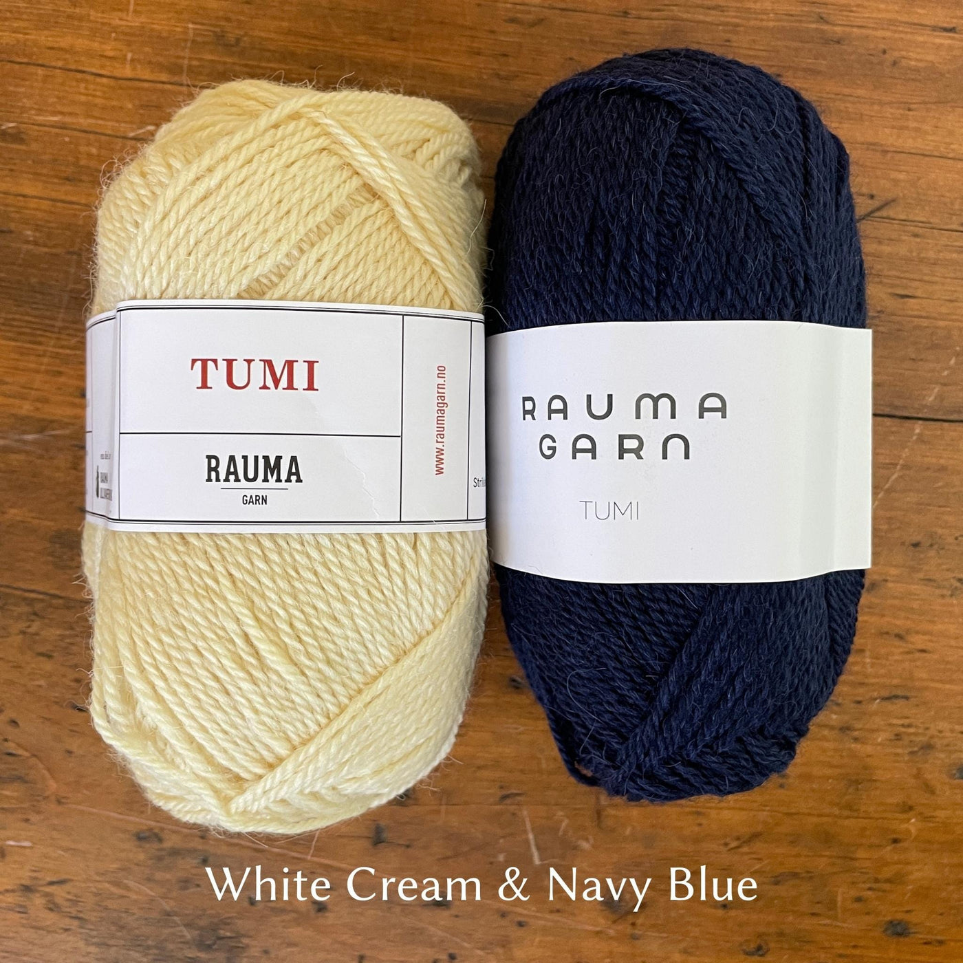Rauma Tumi yarn; one cream ball and one navy blue ball of yarn.