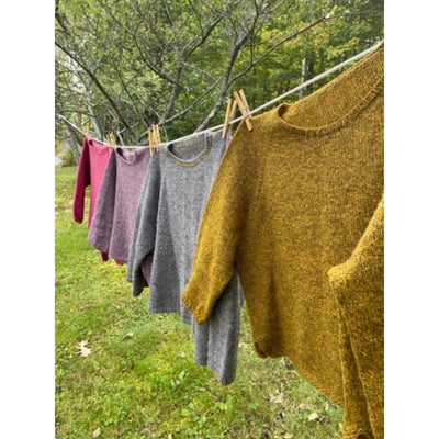 The Woolly Thistle Vanilla sweaters hanging on clothesline.