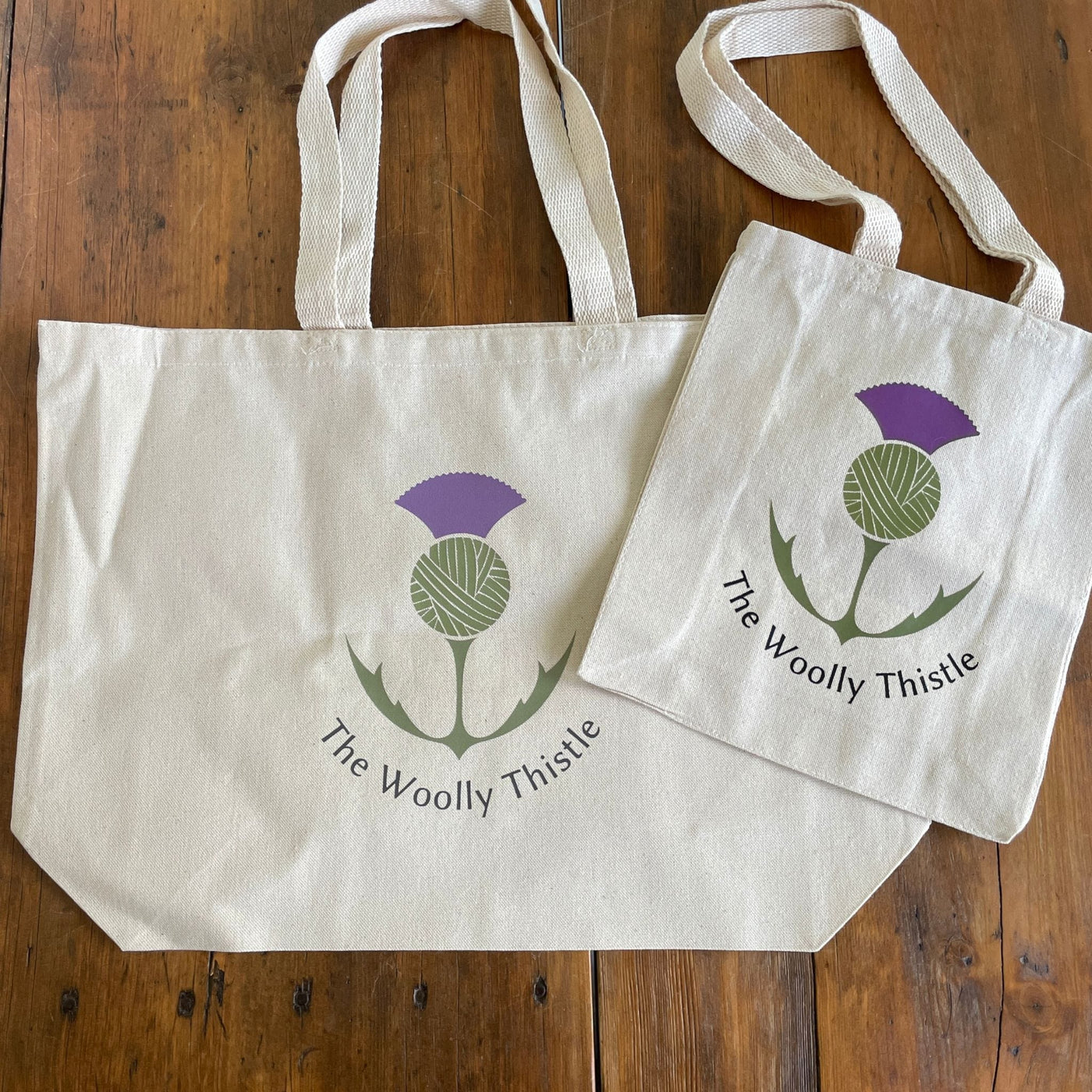 Canvas tote with The Woolly Thistle color logo.  Totes in small and large size. 
