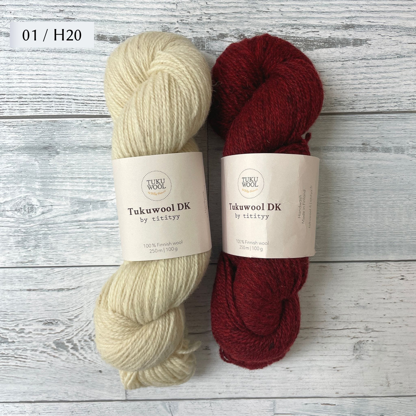 Two Skeins of Tukuwool DK shown as a colorway option for the Muisto Hat & Mittens Set. 01 (cream) and H20 (heathered deep red.)