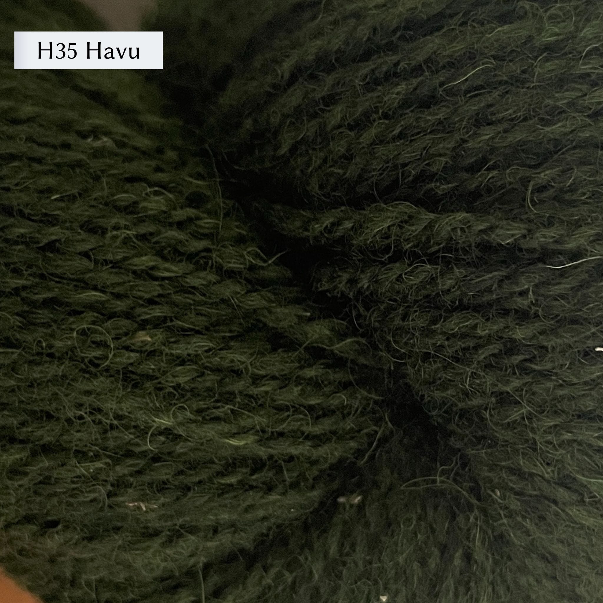 Tukuwool DK Yarn, 100% Finnish Wool shown in colorway H35 Havu which is a heathered dark green color. 