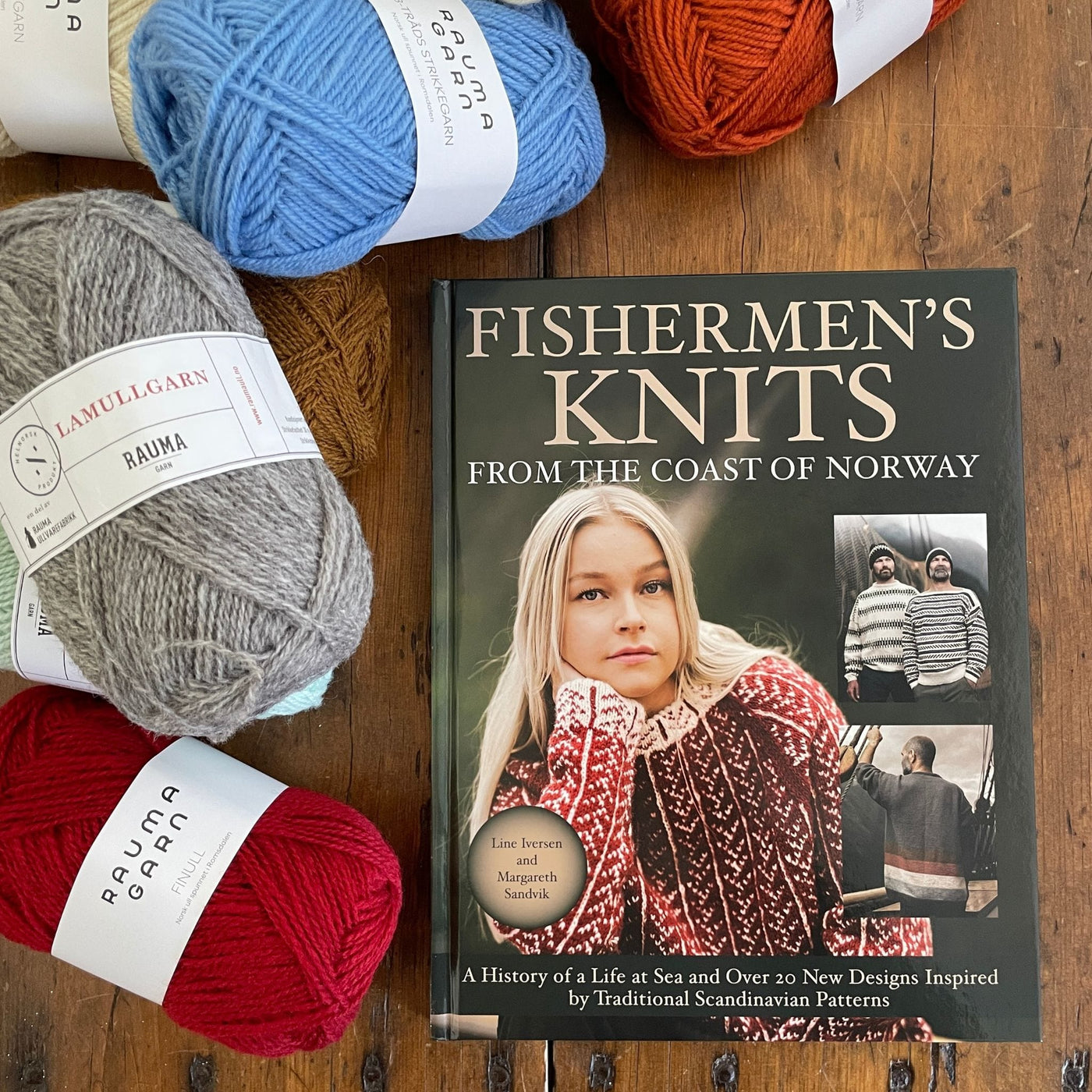 Inside pages of Fishermen's Knits from the Coast of Norway. Book sitting on table surrounded by various Rauma yarn.