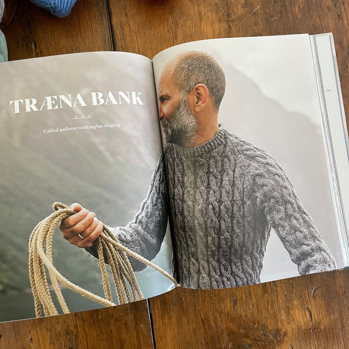 Inside pages of Fishermen's Knits from the Coast of Norway. Pages show a photo of man wearing handknit grey sweater holding rope.