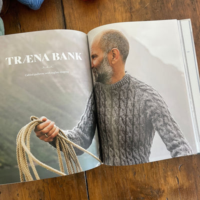 Inside pages of Fishermen's Knits from the Coast of Norway. Pages show a photo of man wearing handknit grey sweater holding rope.
