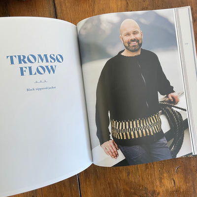 Inside pages of Fishermen's Knits from the Coast of Norway. Pages show a photo of man wearing handknit zippered jacket in black and beige.