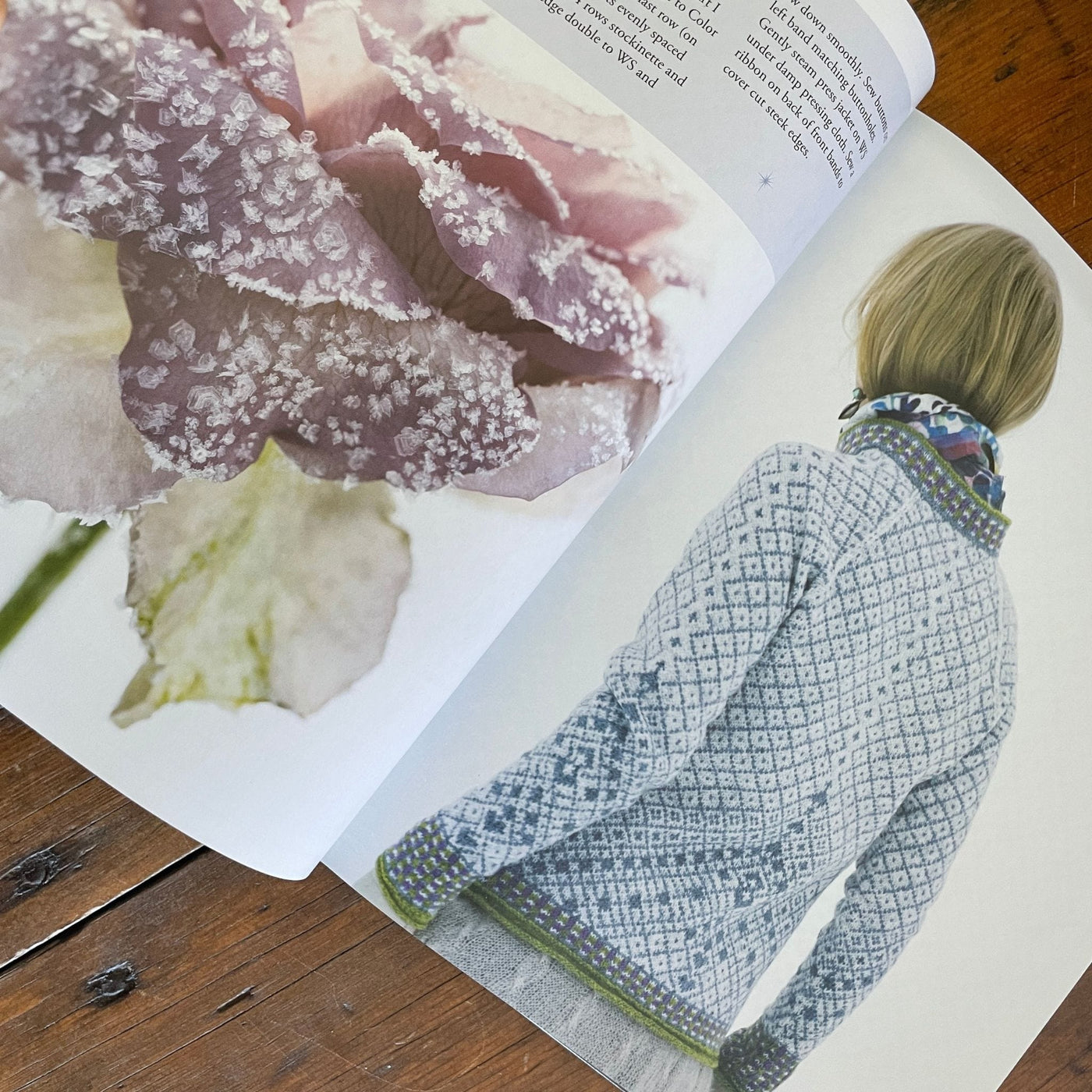 Inside pages of book Norwegian Sweaters & Jackets by Kari Hestnes shows woman wearing yellow colorwork sweater with flower on opposite page.
