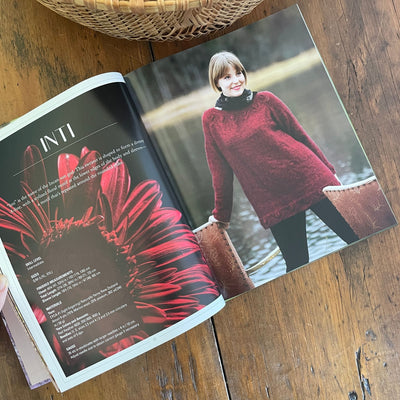Inside pages of book Norwegian Sweaters & Jackets by Kari Hestnes shows woman wearing red sweater design named Inti with pattern detail and flower on opposite page. .