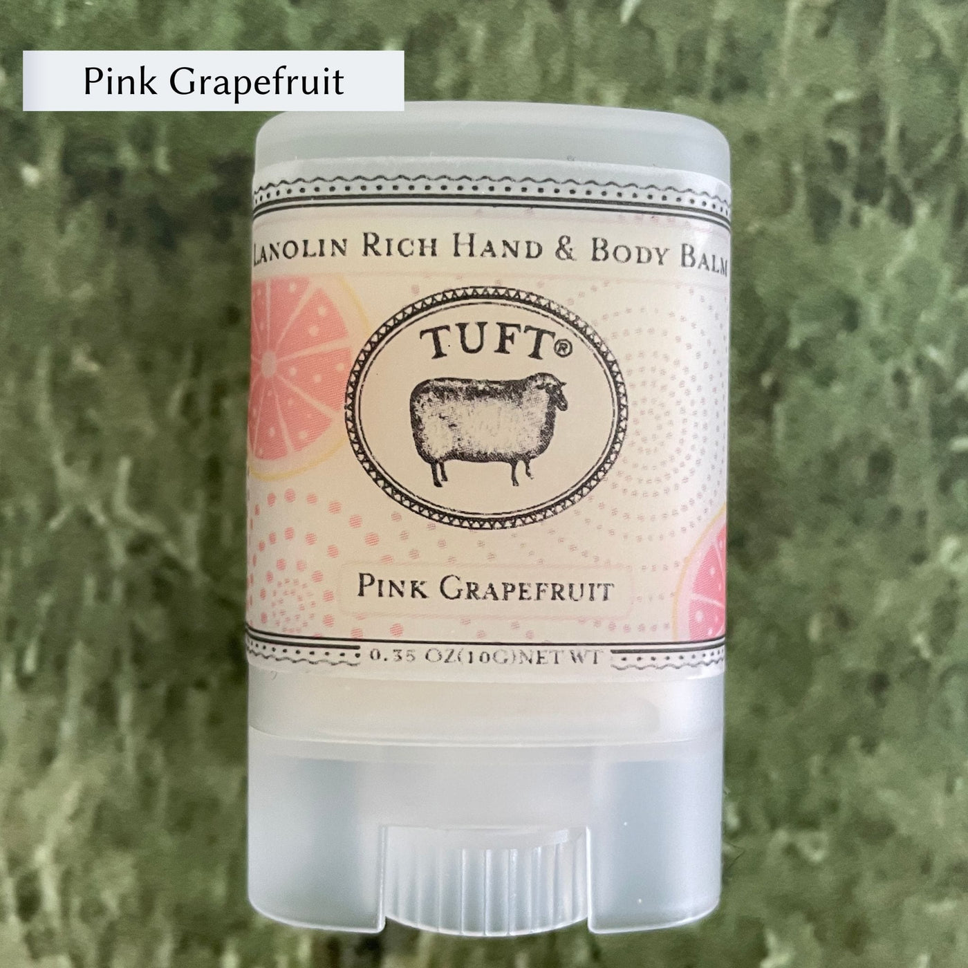 Container of Tufts Woolen Hand & Body Balm in scent called Pink Grapefruit. 