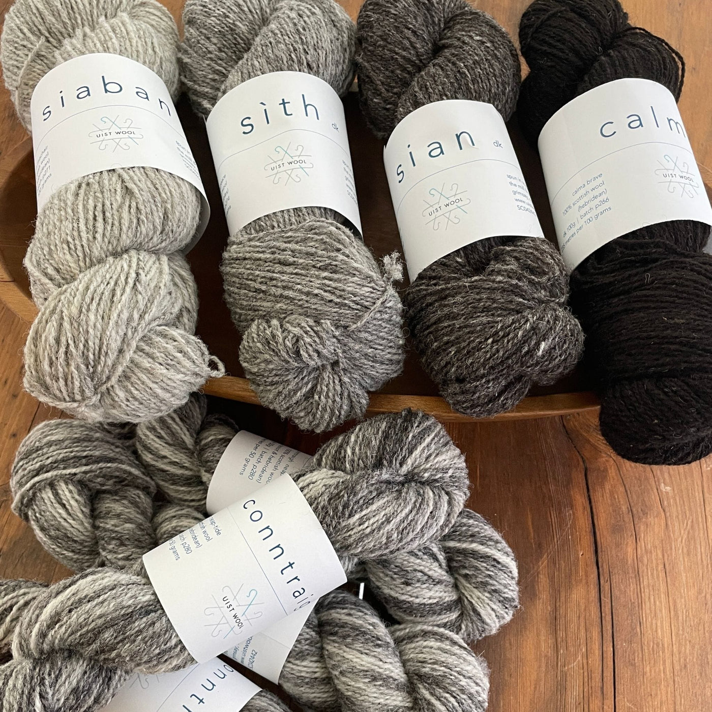 UIST Wool DK weight shown in natural grey to brown skeins.