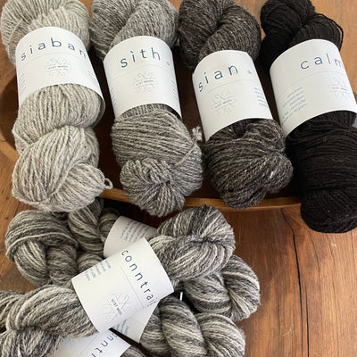 UIST Wool DK weight shown in natural grey to brown skeins.