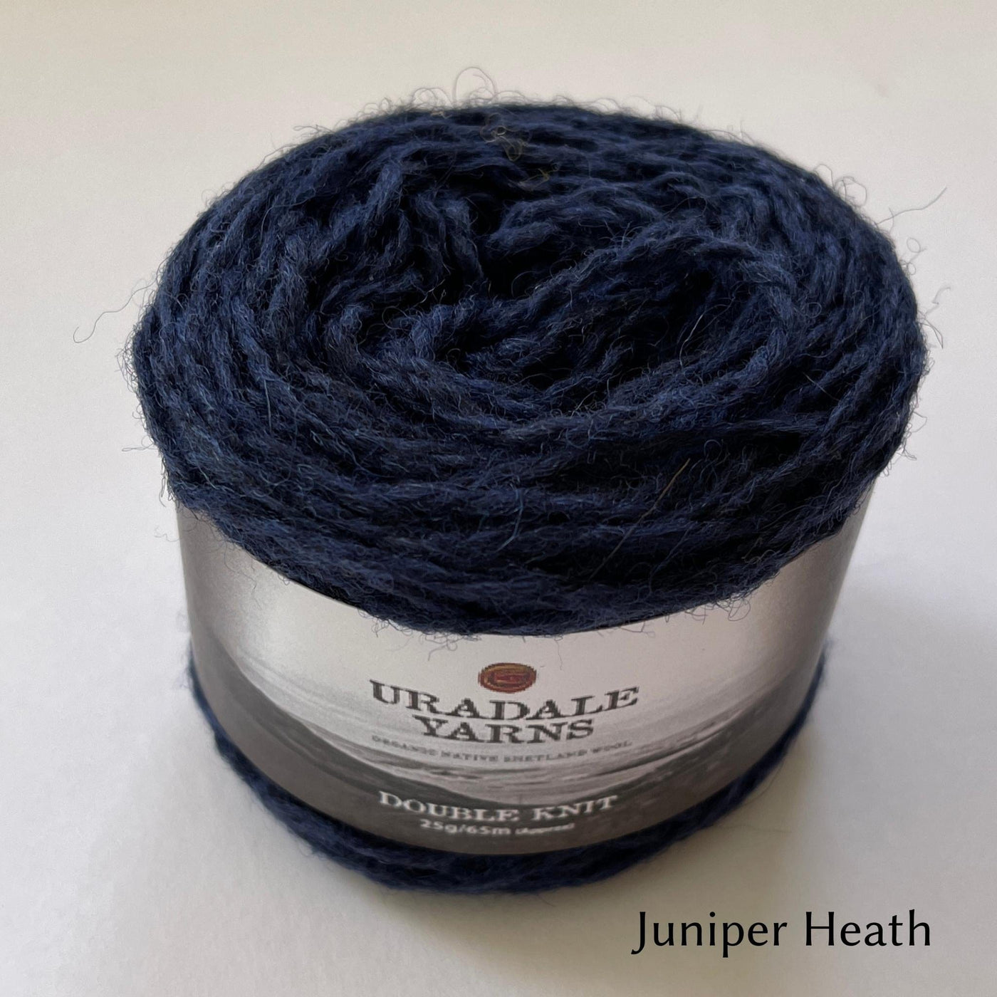 cake of Uradale DK yarn in color Juniper Heath- heathered blue