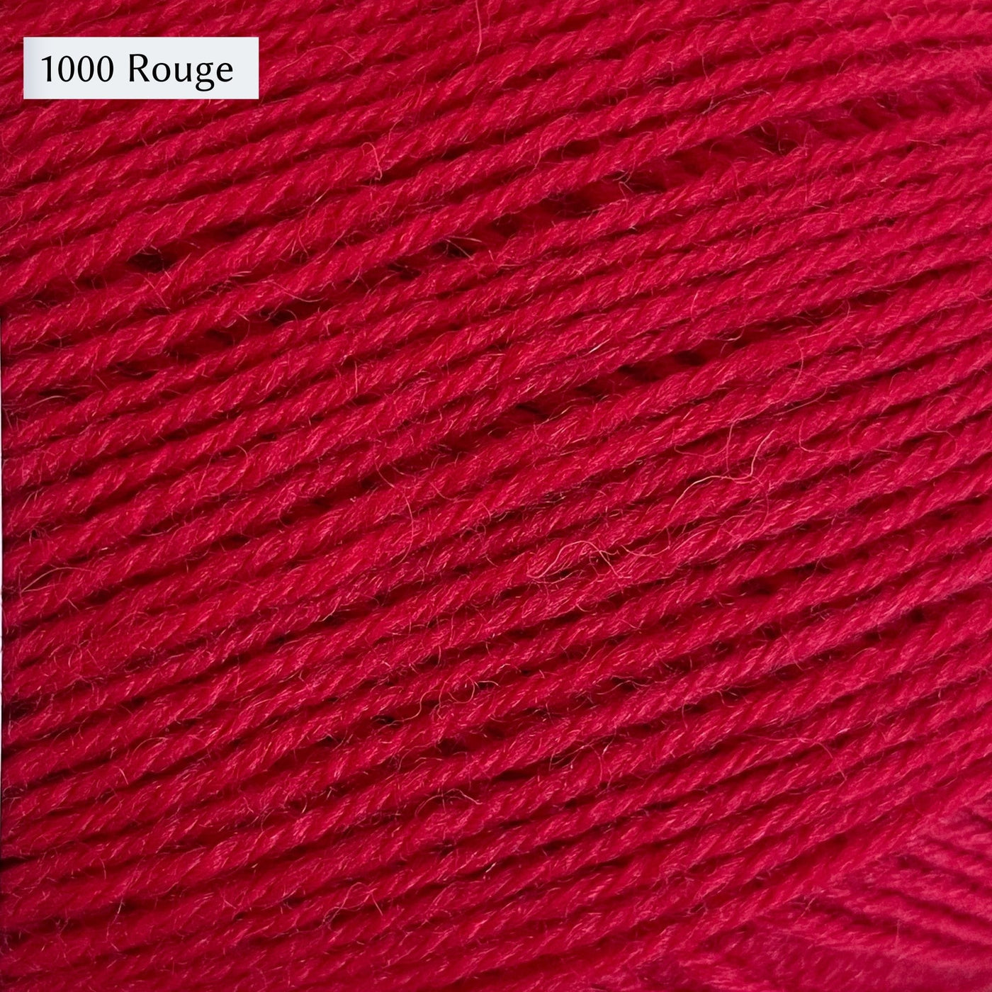 West Yorkshire Spinners Signature 4ply yarn, 100-gram ball, fingering weight, in color 1000 Rouge, a bright, warm red.